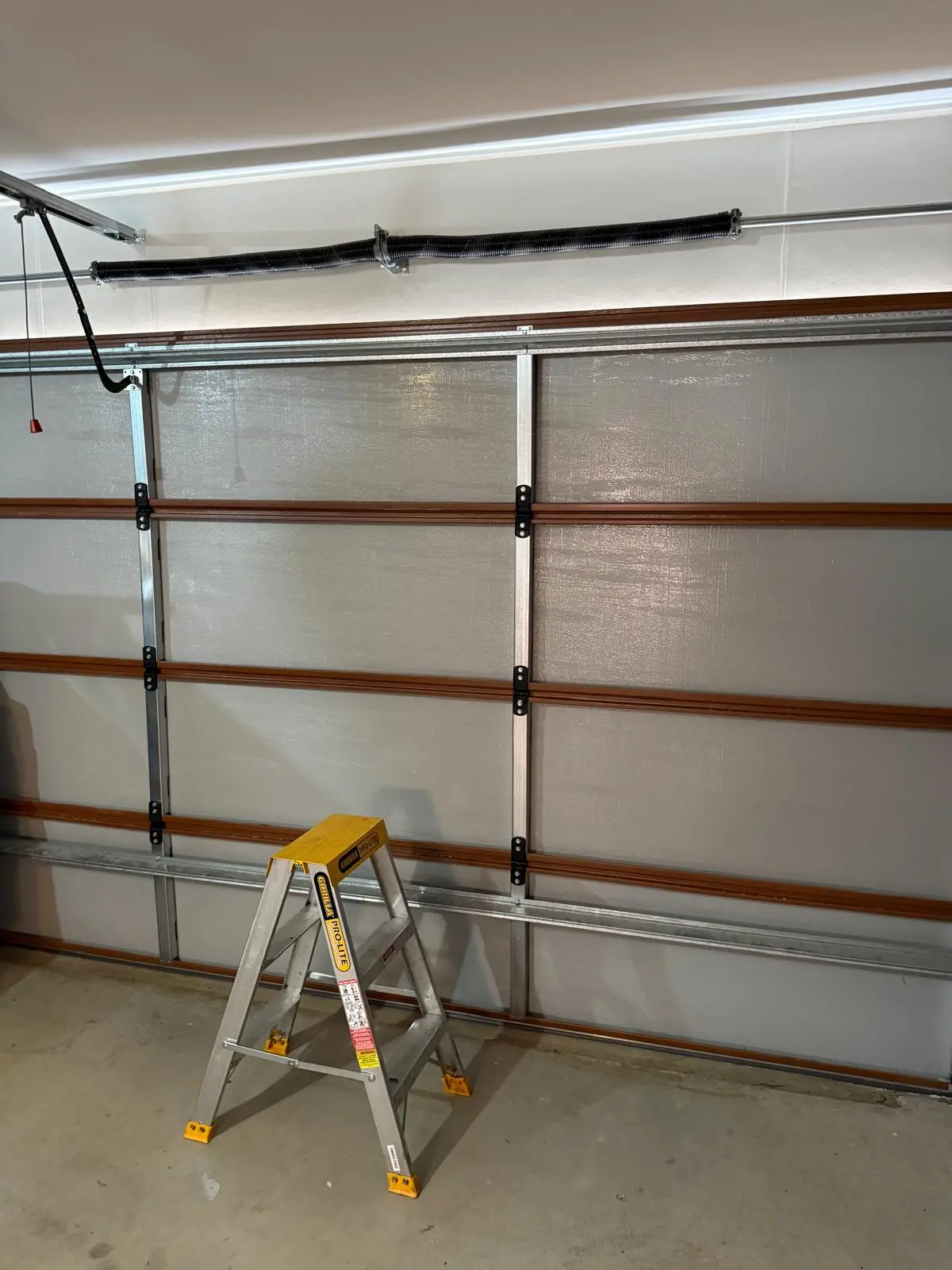 Full sectional garage door interior bracing and track assembly