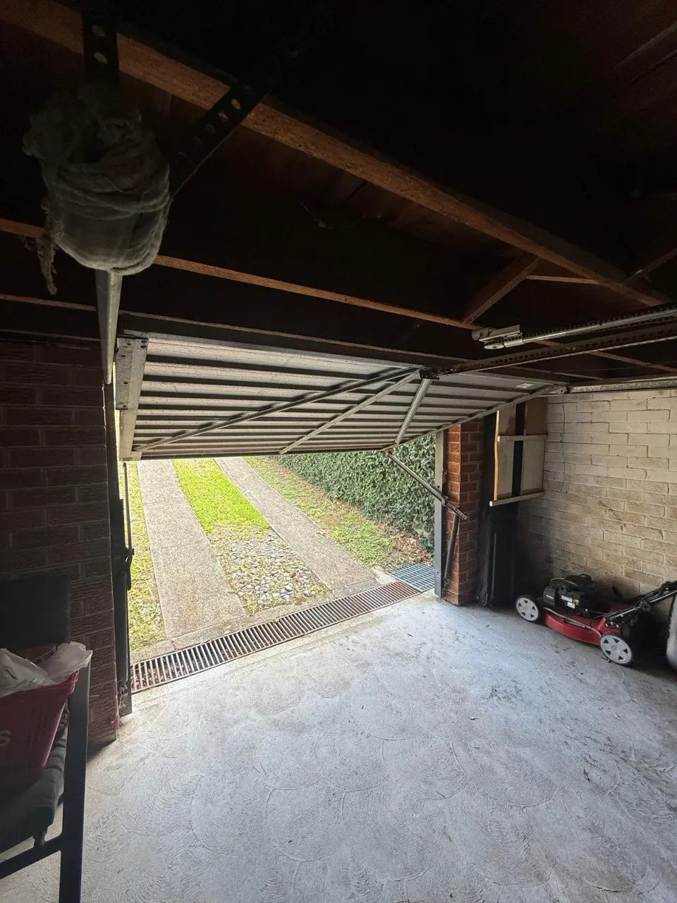 Tilt garage door partially open interior view and motor tow arm